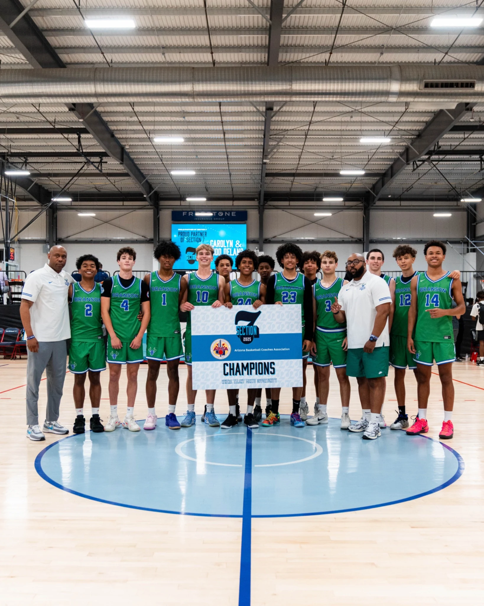 A school basketball team and its coaches with a Section 7 championship sign
