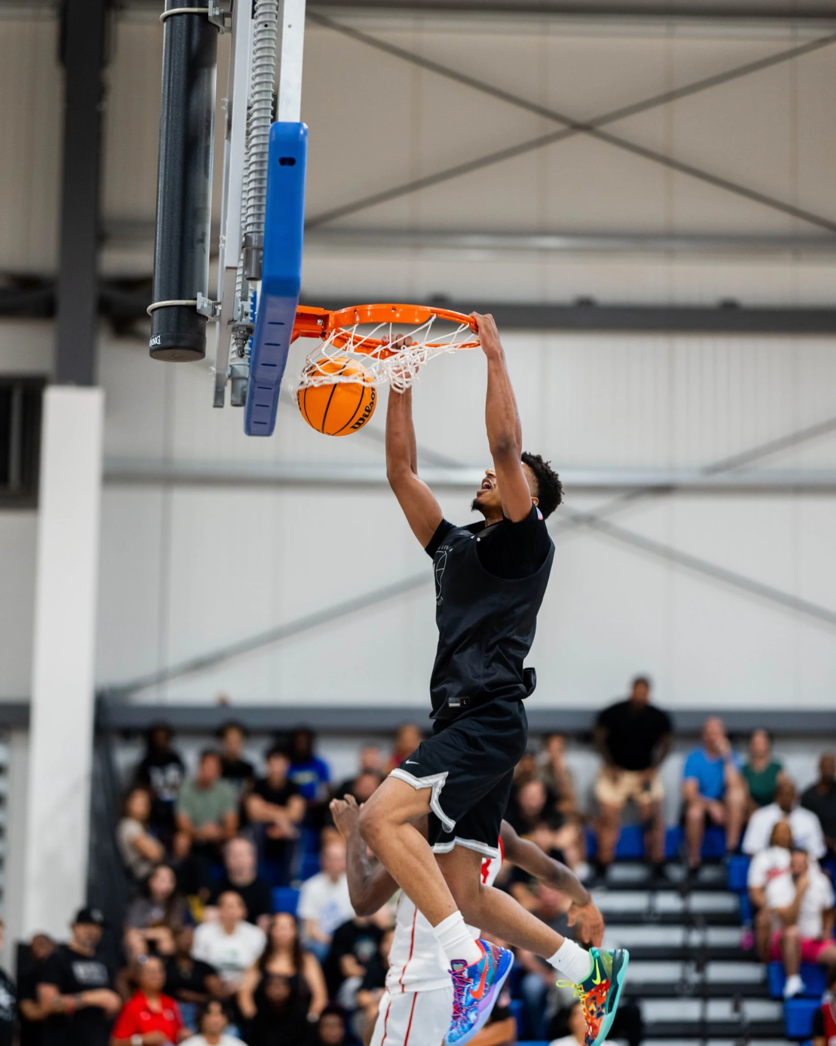 A high school player finishing a dunk at Section 7