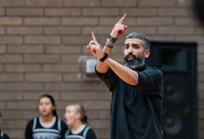 A school basketball coach giving instructions from the sideline