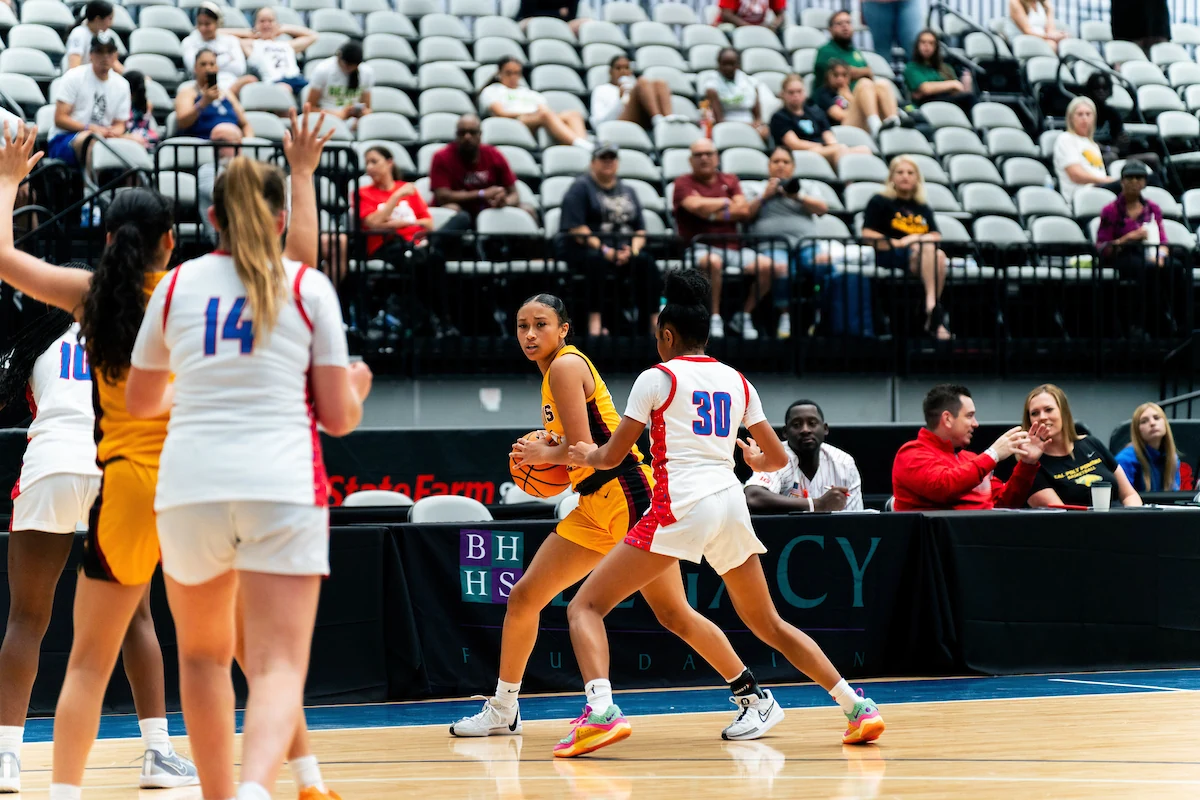 Girls basketball teams competing in a half-court possession
