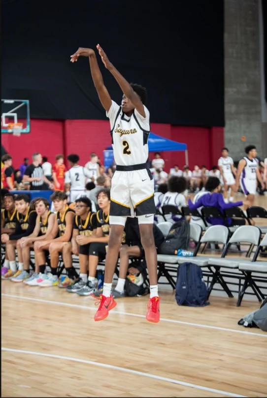 A school basketball player taking a jump shot; general basketball photograph